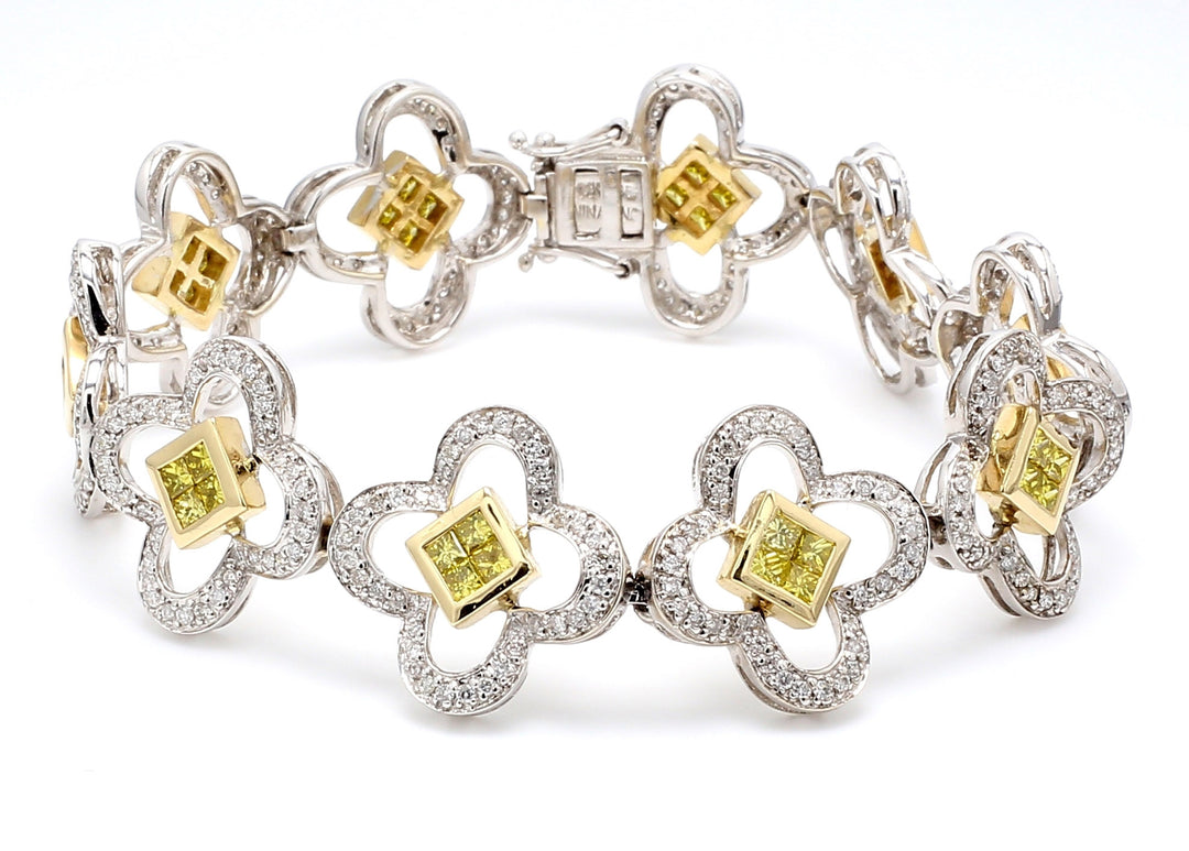 Flower design link bracelet in 2-tone with pave set rounds and 2x2 invisible set princess cut diamonds.  D4.75ct.t.w.