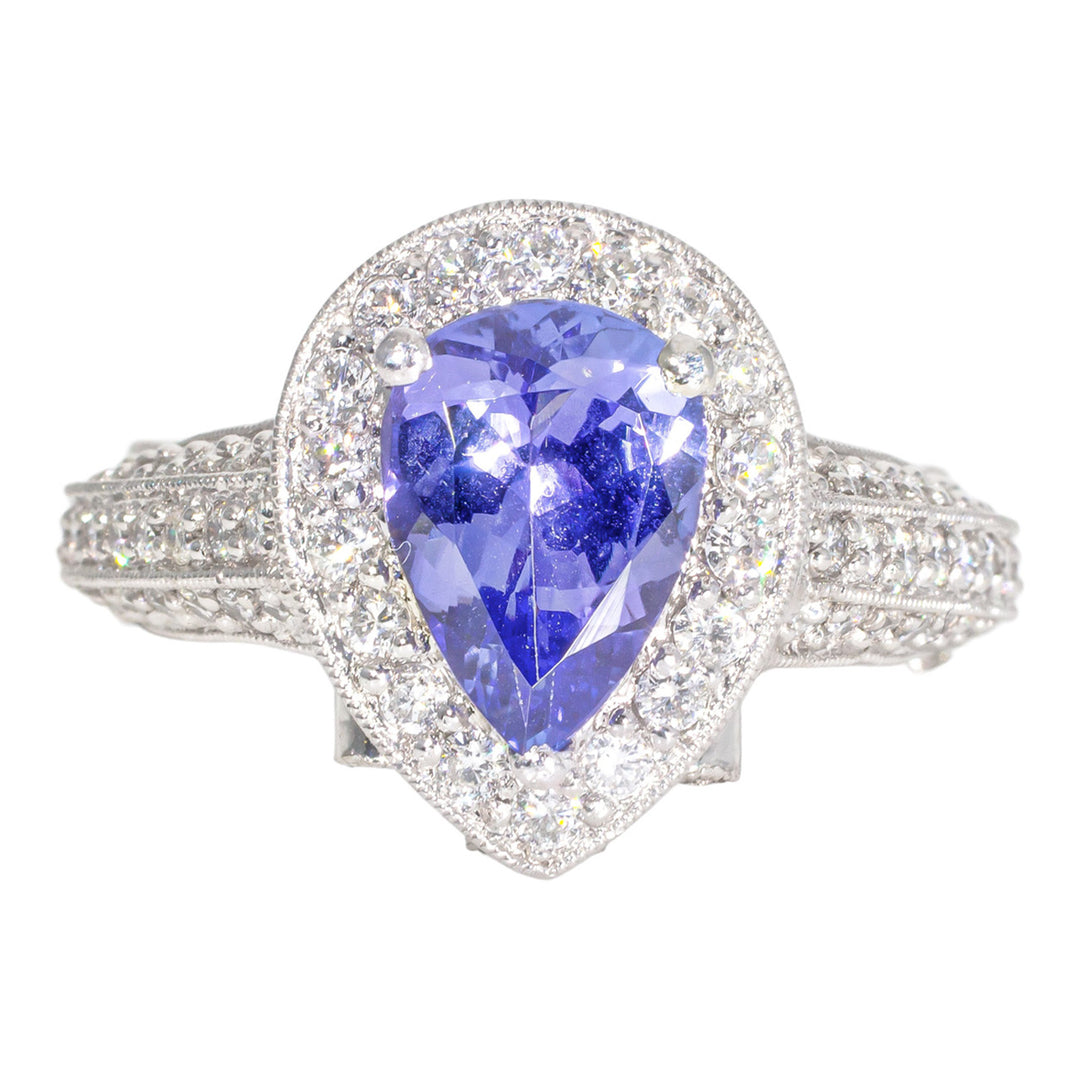 Halo ring in platinum with pave and bezel set round diamonds, and 3-prong set pear shaped tanzanite center stone.  D1.30ct.t.w.  Tanzanite 1.65ct.