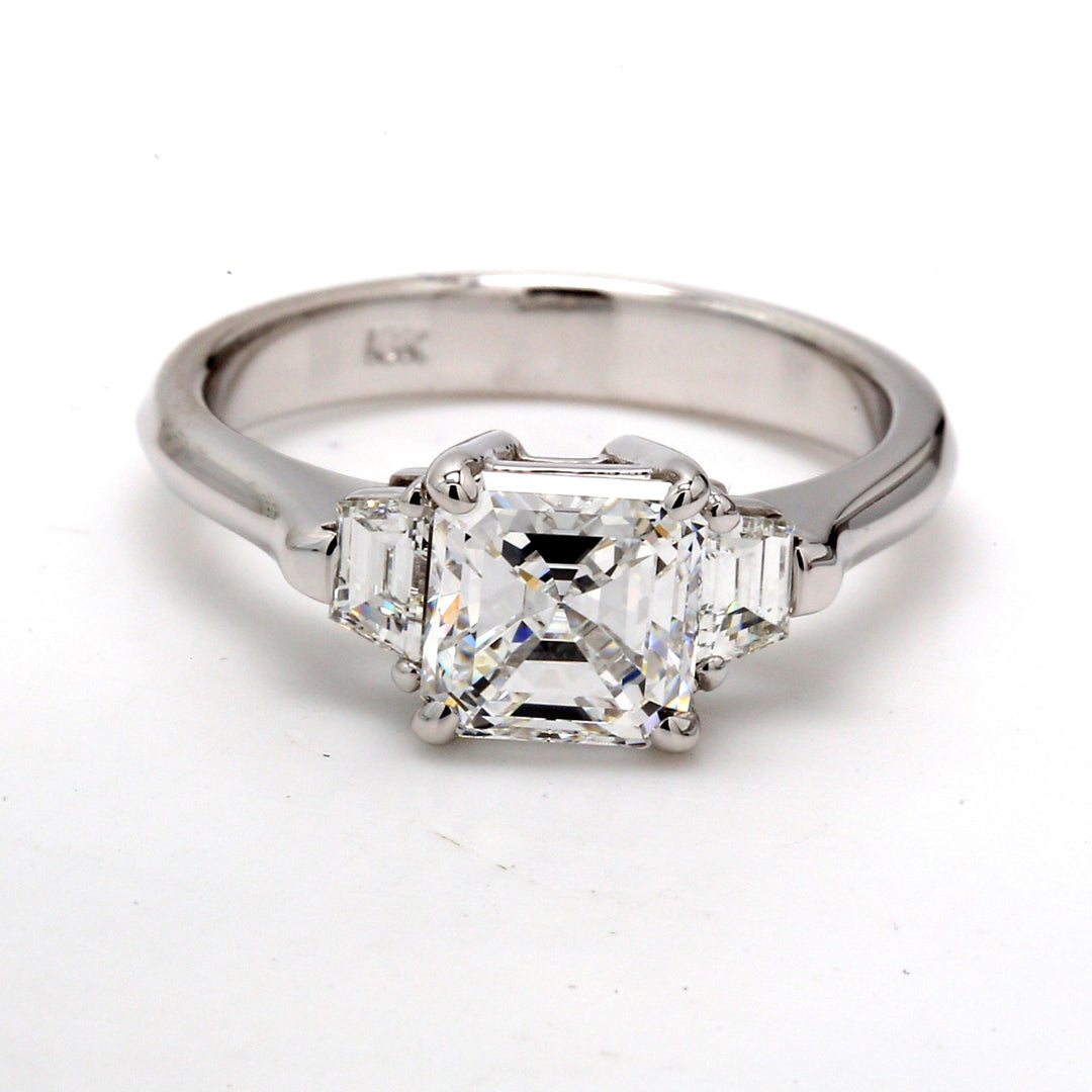 3-stone ring in 18K WG with prong set GIA certified D/VS2 with asscher cut center and 3-prong set trapezoid diamond sides.  D1.94ct.t.w.  (Center 1.60ct.)  Size 6