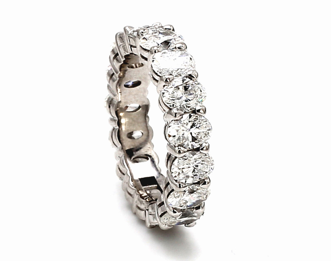 Eternity band in platinum w/ shared prong set oval diamonds & hinge and latch for easy opening.  D3.90ct.t.w.