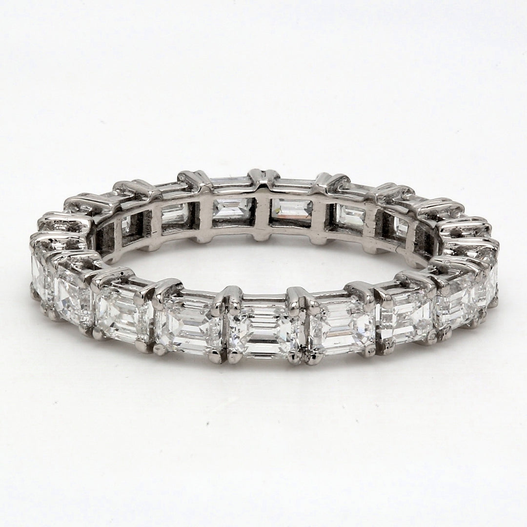 East to west style eternity band in platinum with shared prong set emerald cut diamonds.  D2.57ct.t.w.  Size 7