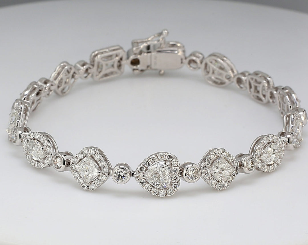 Halo designer tennis bracelet in 18K WG with pre-set rounds around assorted fancy shape diamonds in the center.  D9.78ct.t.w.