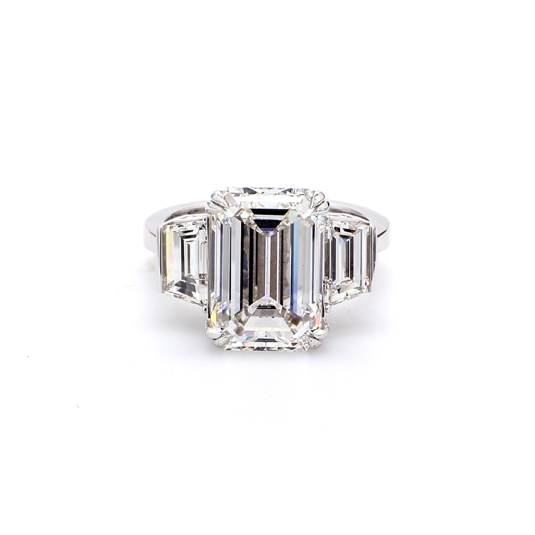 3-stone ring in platinum with double 4-prong set GIA certified F/VS2 emerald cut center and channel set trapezoid diamond sides.  D8.44ct.t.w.  (Center 7.06ct.)