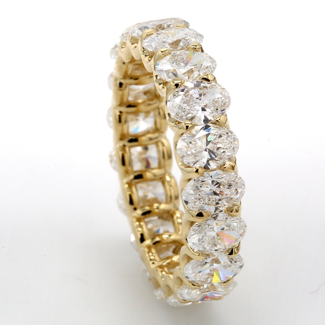 Eternity band in yellow gold with shared U-prong set (19) oval diamonds.  D4.49ct.t.w.  Size 6