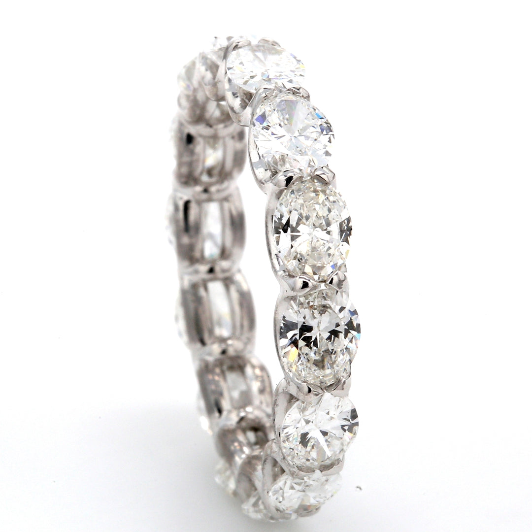 East to west style eternity band in platinum with 4-prong set (14) oval cut diamonds.  D3.55ct.t.w.  Size 6