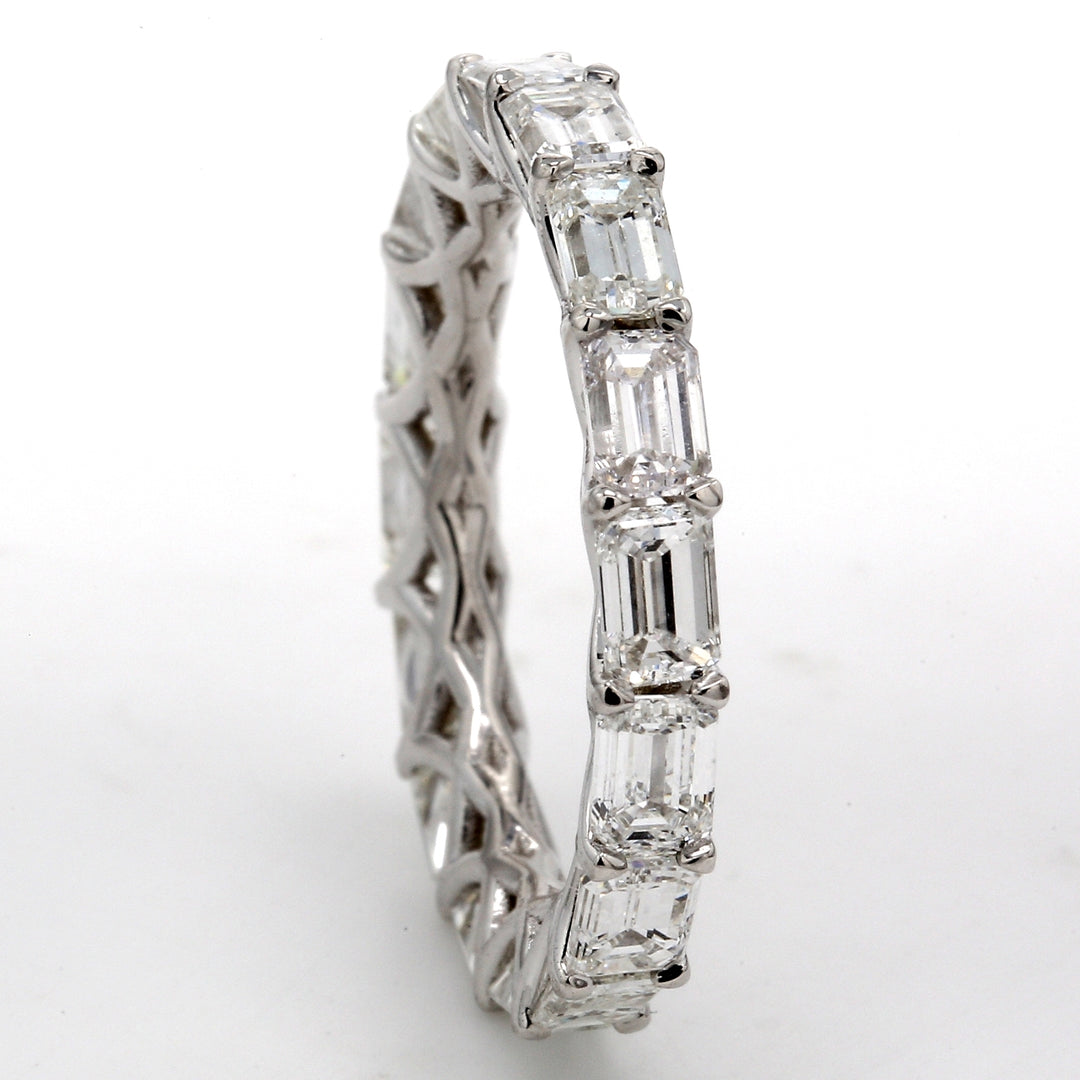 East to west style eternity band in 18K WG with shared U-prong set (16) emerald cut diamonds.  D3.86ct.t.w.  Size 6.75