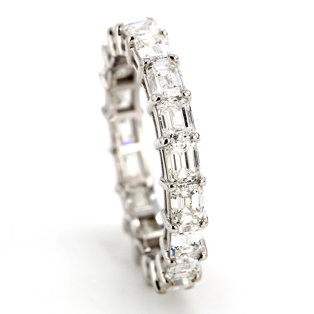 Eternity band east to west style in 18K WG with shared prong set emerald cut diamonds.  D3.66ct.t.w.  Size 7.25