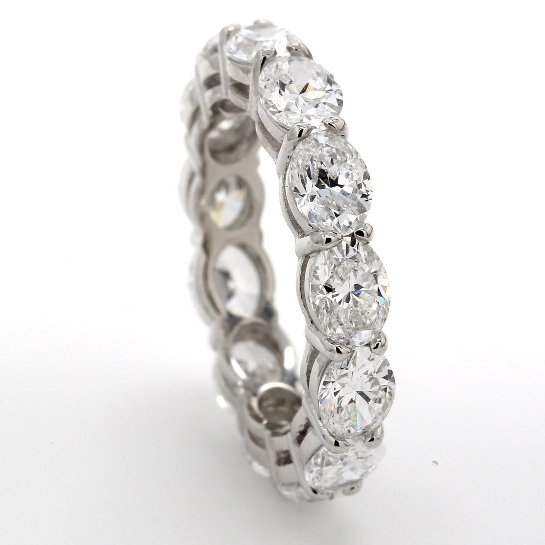 East to west style eternity band in platinum with basket prong set (13) oval diamonds.  D3.94ct.t.w.  Size 5