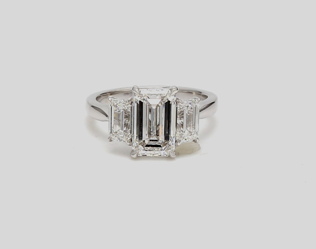 3-stone ring in platinum with GIA certified E/VS1 emerald centerstone and E/VS2 emerald cut diamond sides.  D4.41ct.t.w. (Center - 3.01ct.)