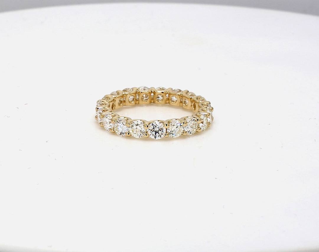 Eternity band in yellow gold with shared u-prong set round diamonds.  D2.96ct.t.w.