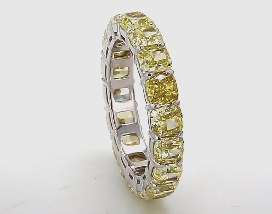 Eternity band in 18K WG with shared prong set fancy yellow (18) cushion cut diamonds.  D6.04ct.t.w.  Size 5.75